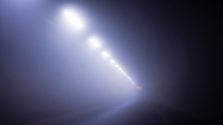 Tunnel lights in dense fog with lens flare and distant red taillights. Clear details and vibrant colors enhanc...の素材