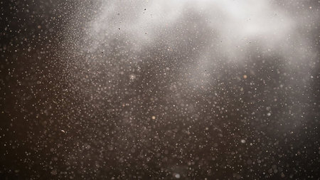 Close-up view of numerous small dust particles floating and illuminated by soft light.の素材