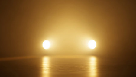 Two bright yellow lights glowing intensely in a dark, foggy, and atmospheric environment.の素材