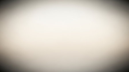 A soft focus gradient transitions from bright white to beige with a dark vignette, creating a subtle and clean abstract background.の素材