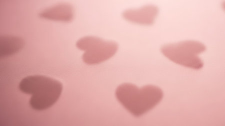 A soft focus pink background with subtle, blurred heart shapes visible. Clear details and vibrant colors enhan...の素材