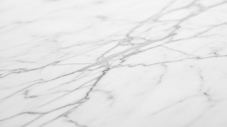 A detailed close-up of a white marble surface featuring delicate grey veins and a smooth, polished texture, offering a clean and backdrop.の素材