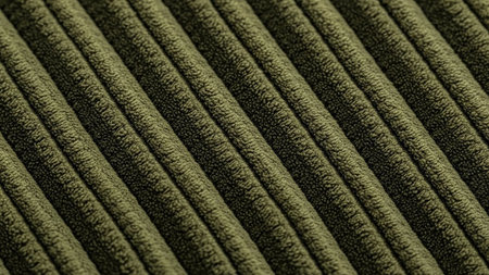 Detailed macro shot of green corduroy fabric showcasing its distinct parallel ridges and soft texture.の素材