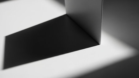An abstract geometric composition featuring a sharp corner casting a strong shadow on a white surface.の素材