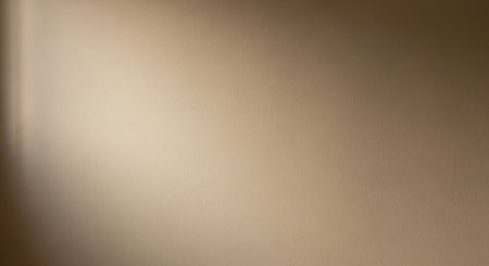 Texture showing softly lit beige wall with subtle texture and diagonal light shadow. resolution use.の素材