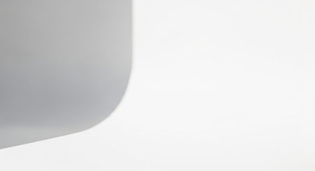 Minimalist abstract of a smooth gray curve against a bright white background with subtle shadowの素材