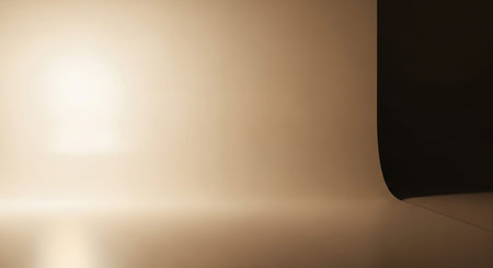 Softly lit studio background with a curved corner and subtle shadow creating a gentle gradient.の素材
