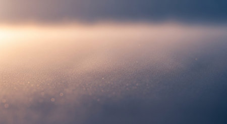 A soft focus abstract background features a warm golden light with a bokeh effect and subtle shimmering...の素材