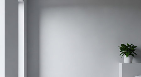 A minimalist interior wall with soft light casting shadows and a small green plant in a white pot.の素材