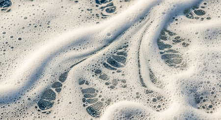 Pattern showing close-up macro view of white sea foam bubbles and swirling patterns on dark blue water surface keywords: sea, foam, bubbles, water,...の素材