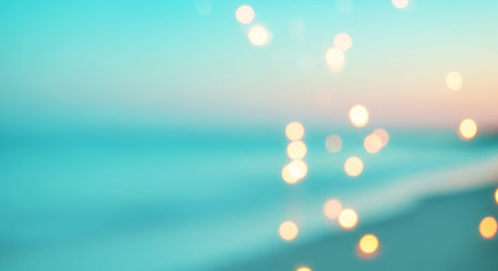 Soft focus bokeh lights create a dreamy atmosphere over a blurred turquoise ocean and sandy beach at dusk.の素材