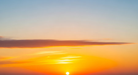 Sunset showing vibrant orange sunset sky with wispy clouds and a faint horizon line creating a serene and peaceful atmosphere. resolutionの素材