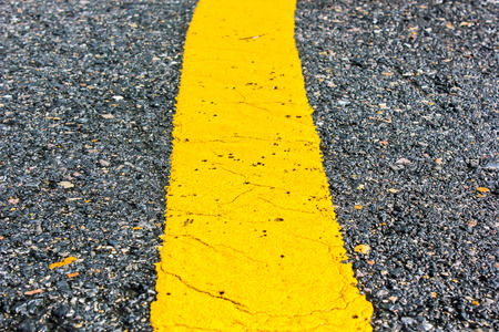 asphalt road yellow line close up backgroundの写真素材