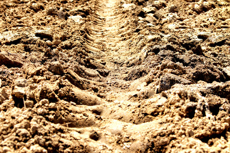 traces of the wheel off-road truck tire on the dried soil background patternの写真素材