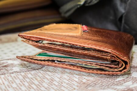 close-up brown leather wallet of traveler on tableの写真素材