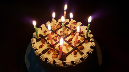 birthday cake with bright lights of candles isolated on backgroundの写真素材