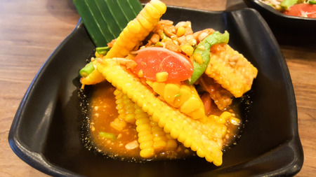 corn salad with vermicelli and salted crab on black dishの写真素材