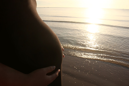 Pregnant women with sea and sunset landscape view