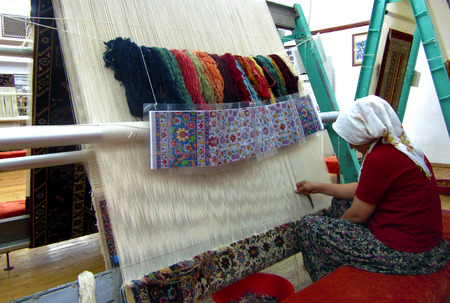 Avanos Oren Yeri, Goreme, Cappadocia, Turkey, September 22, 2013 - A woman making a Turkish silk carpet, also known as Anatolian, at Avanos Hali.のeditorial素材