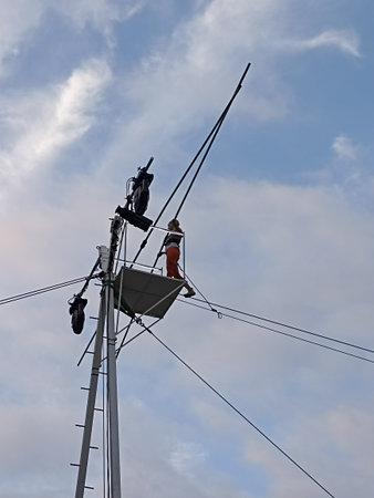 Workers on a high-voltage power line against the skyの写真素材