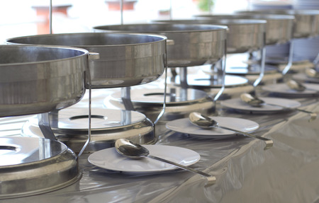 A few chafing on a banquet table with a blurred background of a wedding decorations.の写真素材