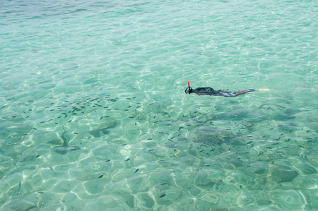 A man snorkeling in turquoise water near Pulau Payar Marine Park, Malaysiaの写真素材
