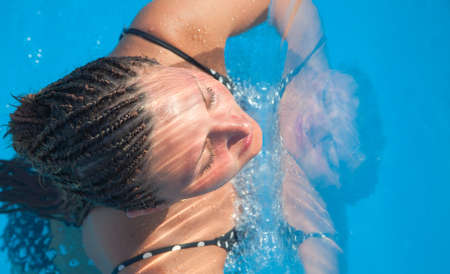 European woman with an African hairstyle in waterの写真素材