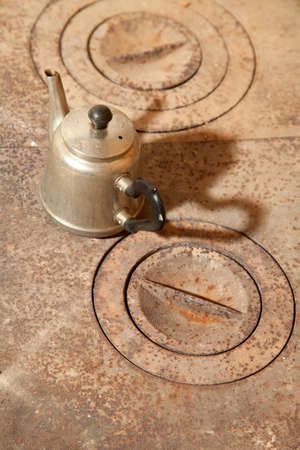 Kettle on a rusty old cast iron stoveの写真素材