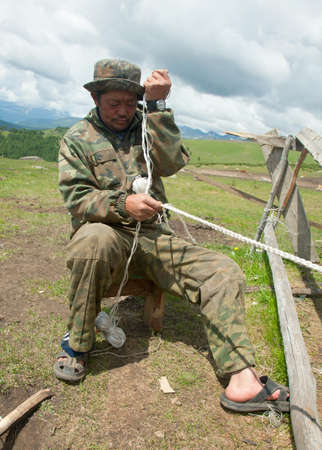 Man nomad weaving rope to tie the horses