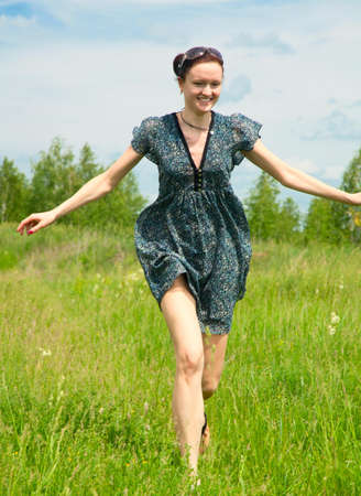 Young woman running on green grassの写真素材