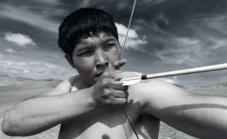 A young man shoots a bow. A man of Asian appearanceの写真素材