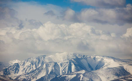 Snow-capped mountain peaks under the cloudsの写真素材