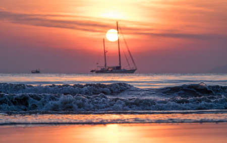 Sailing yacht at sunset in the tropical seaの写真素材