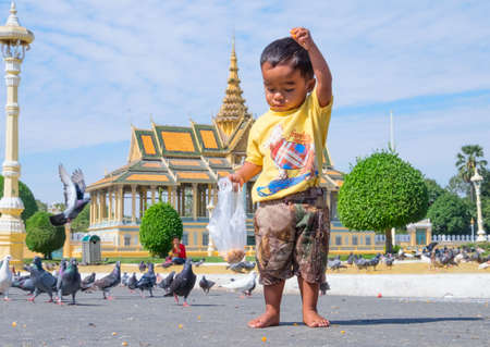 PHNOM PENH, CAMBODIA - JANUARY 5, 2015:  A small child in front of a Buddhist templeのeditorial素材