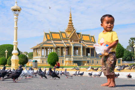 PHNOM PENH, CAMBODIA - JANUARY 5, 2015:  A small child in front of a Buddhist templeのeditorial素材