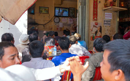 PHNOM PENH, CAMBODIA - JANUARY 10, 2015: Street cafe is broadcast Thai Boxing, Phnom Penh , Cambodia January 2015のeditorial素材