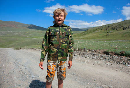 Boy camouflage outdoors in the mountainsの写真素材