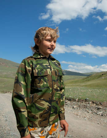 Boy camouflage outdoors in the mountainsの写真素材