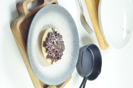 Serabi the indonesian traditional Pancakes made from coconut milk, with chocolate topping on white plate on wooden tray.の写真素材