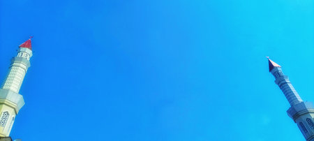 Beautiful view of two mosque minarets reaching into the sky. Iconic religious architecture for travel and cultural themesの写真素材