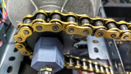 Side View of a Chain Drive Transmission System Linking an Electric Motor to a Rotating Mechanical...