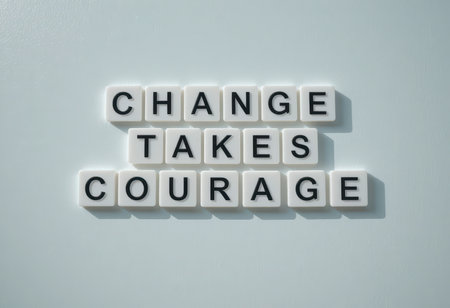 A motivational arrangement of letter tiles spelling "Change Takes Courage," symbolizing the importance of bravery in personal transformation and growth.の素材