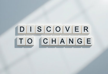 A creative arrangement of letter tiles spelling "Discover To Change" on a minimalistic light background, symbolizing personal growth and inspiration. Perfect for motivational themes.の素材