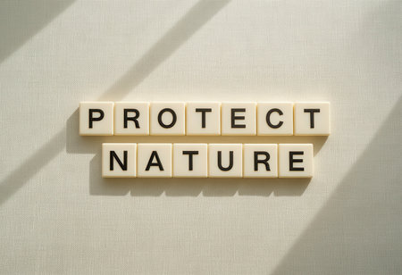 A creative arrangement of wooden letter tiles spells "Protect Nature" against a textured backdrop. This image promotes environmental awareness and sustainability.の素材