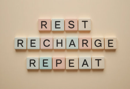 A visually appealing arrangement of wooden blocks spelling "Rest Recharge Repeat," promoting wellness and self-care. Ideal for wellness-themed content.の素材