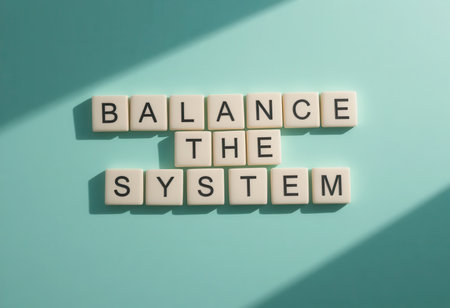 Playful arrangement of letter tiles spelling "Balance the System" on a turquoise background. This image evokes concepts of harmony, motivation, and organization.の素材