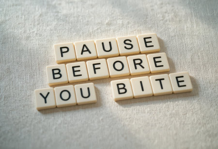 Inspiring visual featuring letter tiles arranged to convey a mindful eating message. Encourages individuals to pause before making food choices.の素材