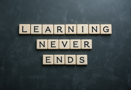 A motivating display of the phrase "Learning Never Ends" using large letters on a dark surface, symbolizing the continuous journey of education and personal growth.の素材