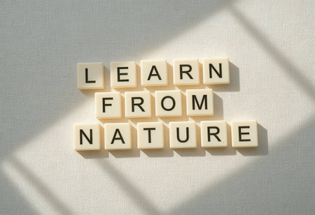 A creative arrangement of letter blocks that forms the phrase "Learn from Nature," symbolizing growth and inspiration through the beauty of the natural world.の素材