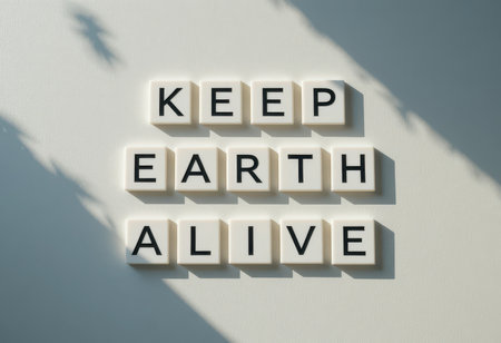 This image features an inspirational message, "Keep Earth Alive," creatively arranged with letter tiles on a soft background. Ideal for environmental themes.の素材